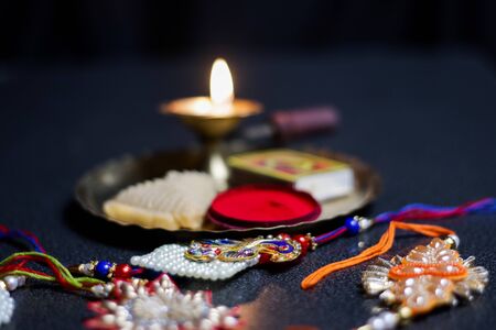 a plate thali decorated with rakhi sweet lamp diya for the occasion of rakshabandhan greeting of brother and sisterの写真素材
