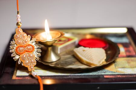 a plate thali decorated with rakhi sweet lamp diya for the occasion of rakshabandhan greeting of brother and sisterの写真素材