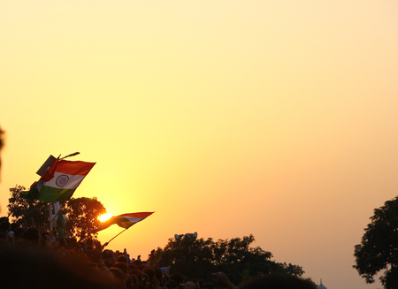 August 15,2018, Wagha Border, Amritsar, India. Indian flag waved by crowd during sunset at Wagha,...