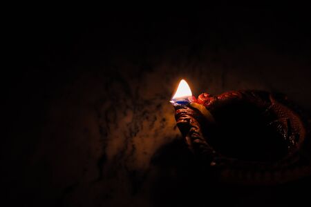 earthen oil lamp lit on the occasion of deepavali, a hindu festival of light with selective focus on...