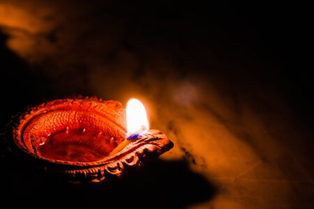 earthen oil lamp lit on the occasion of deepavali, a hindu festival of light with selective focus on...