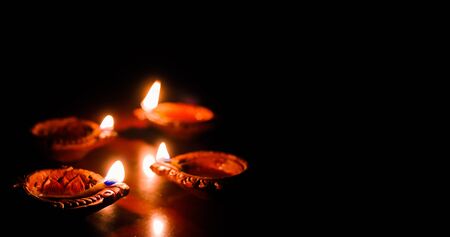 earthen oil lamp lit on the occasion of deepavali, a hindu festival of light with selective focus on lamp and background and foreground blurの写真素材