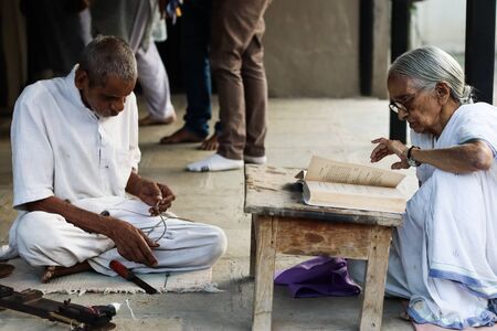 November 30, Maharashtra India,- An elderly man and lady lady in white dress reading books and...