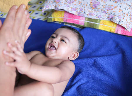 an infant toddler baby boy smiling on a blue towelの写真素材