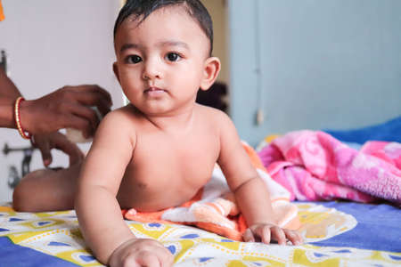 an infant toddler baby boy wet with foam enjoying shower bathing rubbed by towelの写真素材
