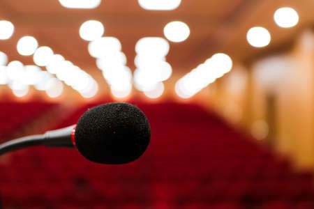 close up photo of a microphone with blurred background & bokeh lights of auditorium with selective focus on microphone Stage mic fear concept imageの写真素材