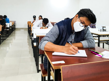 December 8, 2020.Lucknow Uttar Pradesh,India. West Bengal India. Medical students writing examination paper in mask maintaining social distancing at Radheshwam Medical College,Lucknow, UP, India.のeditorial素材