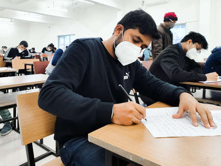 December 8, 2020.Lucknow Uttar Pradesh,India. West Bengal India. Medical students writing examination paper in mask maintaining social distancing at Radheshwam Medical College,Lucknow, UP, India.のeditorial素材