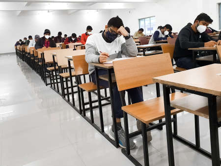 December 8, 2020.Lucknow Uttar Pradesh,India. West Bengal India. Medical students writing examination paper in mask maintaining social distancing at Radheshwam Medical College,Lucknow, UP, India.のeditorial素材