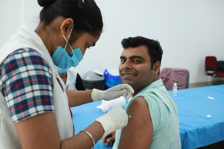 February 20,2021, Kishanganj, Bihar, India. Nursing staff holding used empty vials of Covishield vaccine with gloved hand after vaccination session at MGM Medical College, Kishanganj, Bihar.のeditorial素材