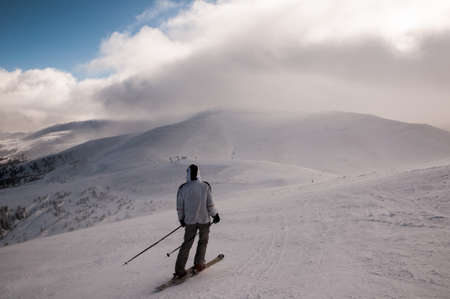 Skier in mountains, prepared piste and sunny day.の写真素材