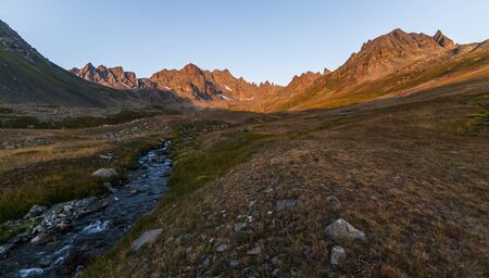 Colorful summer sunrise in the mountains with rolling hills and valleys in golden morning lightの写真素材