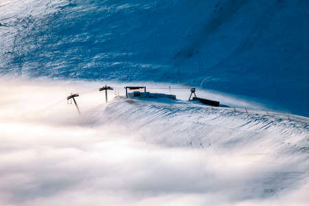 Peaks above clouds, winter mountains, foggy morning