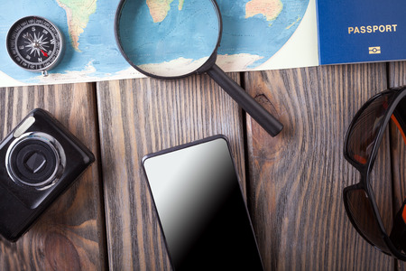 Preparation for Traveling concept, passport, smartphone, camera, map on a wooden backgroundの写真素材