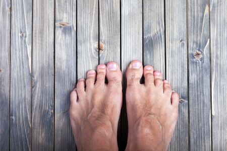 male feet on wooden backgroundの写真素材