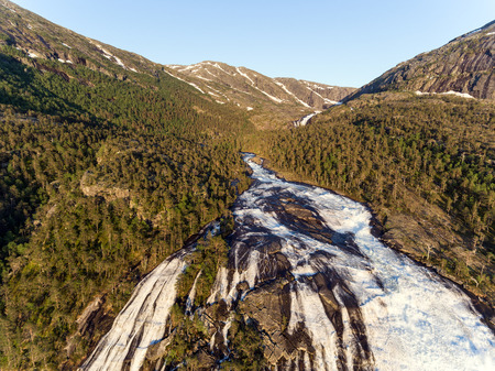 Photo of Rapid Stunning Waterfall in Husedalen Valley, Norway. Aerial view. Summer time.