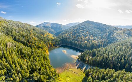 big lake in the middle of mountains during autumnの写真素材