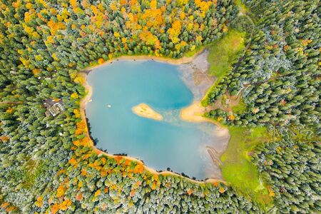 big lake in the middle of mountains during autumnの写真素材