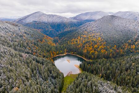 big lake in the middle of mountains during autumnの写真素材