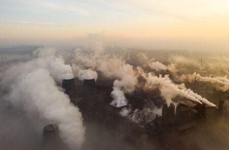 Aerial view. Pipes Throwing Smoke in the Sky. Large Plant on the Background of the City.の写真素材