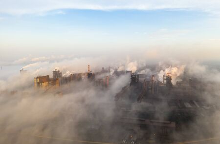 Aerial view. Pipes Throwing Smoke in the Sky. Large Plant on the Background of the City.の写真素材