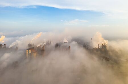 Aerial view. Pipes Throwing Smoke in the Sky. Large Plant on the Background of the City.の写真素材
