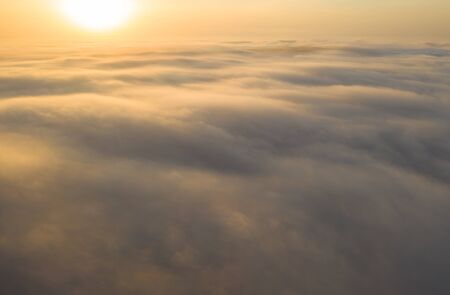 Flying over the evening clouds with the late sun.の写真素材