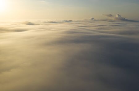 Flying over the evening clouds with the late sun.の写真素材