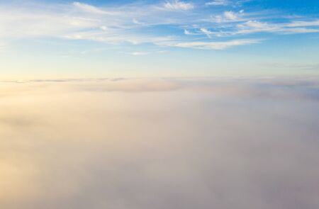 Flying over the evening clouds with the late sun.の写真素材
