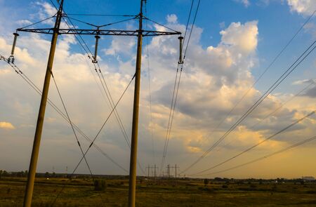 electricity pylons and high voltage power line at sunset.の写真素材