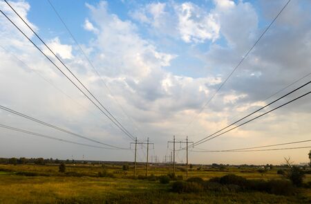electricity pylons and high voltage power line at sunset.の写真素材