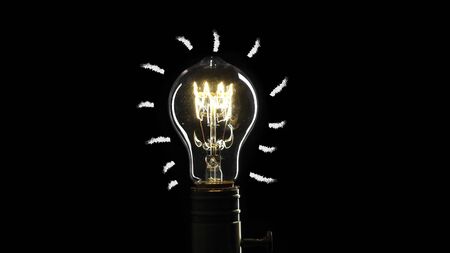 idea light bulb Flickering Tungsten light bulb lamp over black backgroundの写真素材