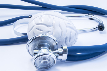 Concept of visualization or imaging diagnosis and treatment of diseases of brain using brain model and stethoscope, which like examine of brain, close up in fluorescent blue color on white backgroundの写真素材