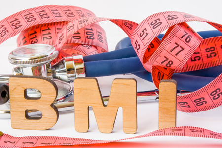 BMI or body mass index abbreviation or acronym photo concept in medical diagnostics or nutrition, diet. Word BMI is on background of tape to measure the circumference of body and medical stethoscopeの写真素材
