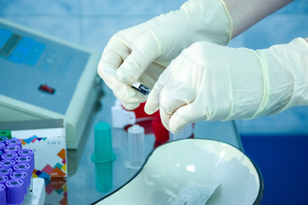 Preparation of laboratory equipment for urgent or routine medical procedure. Nurse or doctor opens package with medical laboratory tool for blood collection or intravenous administration of drugsの写真素材