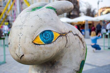 Artistic figure of the Easter Bunny in grey with big blue eyes and yellow, with painted runes and the mysterious marks on the skin. Beautiful art easter decoration .Kyiv (Kiev), Ukraine, april 2018のeditorial素材