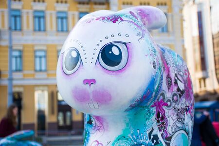 Easter bunny or rabbit figure in purple and blue colors with big eyes close up on a background of the old house. Beautiful art easter decorationsのeditorial素材