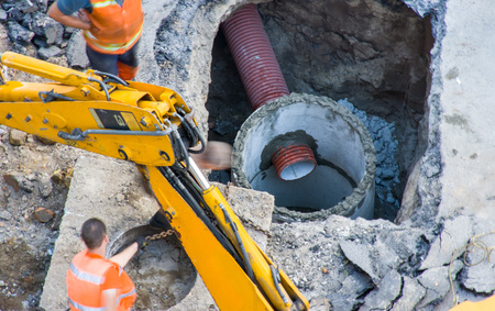 Photo of construction or active repair water supply, sewer or pipe drainage system in concrete pit...