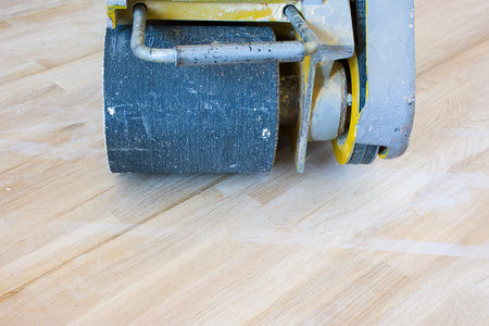 Front view of scraping machine or grinder for  process of scraping of wood parquet, hard wood floor or other type of floor is ready for use. Carpenters work photoの写真素材
