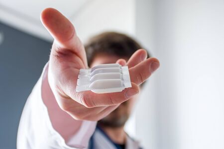 Treatment with medication in form of suppositories concept photo. Doctor  holding in his...
