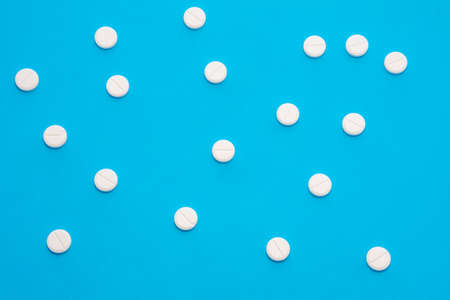 Background for pharmacy or medicine. White pills with medicine are on a blue uniform background, forming a polka dot patternの写真素材