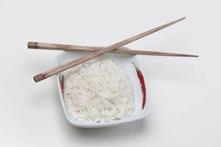 A bowl of perfectly cooked, plain Basmati rice, in an Asian style bowl, with a garnish of Thai Basilの写真素材