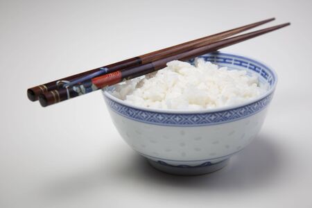 A bowl of perfectly cooked, plain Basmati rice, in an Asian style bowl, with a garnish of Thai Basilの写真素材