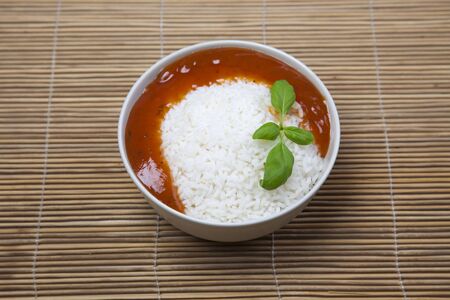 A bowl of perfectly cooked, plain Basmati rice, in an Asian style bowl, with a garnish of Thai Basilの写真素材