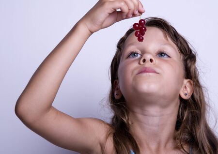 A little girl with currantの写真素材