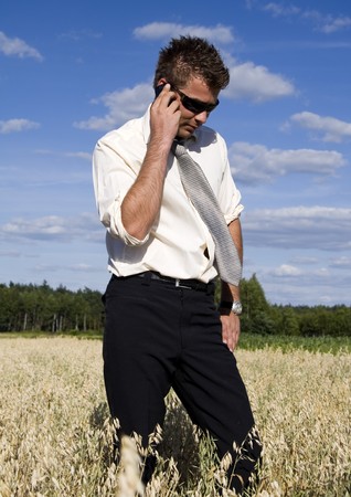 A businessman dressed in a smart suit standing on grassの写真素材
