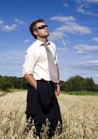 A businessman dressed in a smart suit standing on grassの写真素材