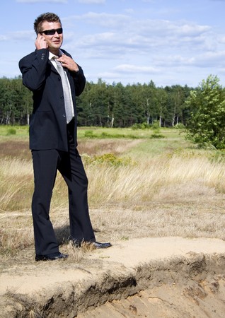 A businessman dressed in a smart suit standing on grassの写真素材