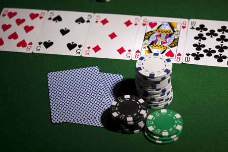 Poker cards and gambling chips on green backgroundのeditorial素材