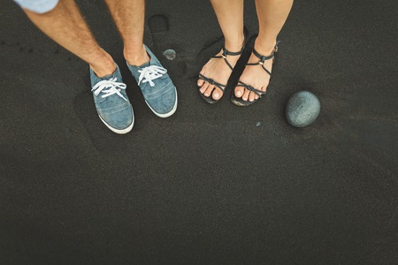 Foot stand on black sand stone. Man and woman